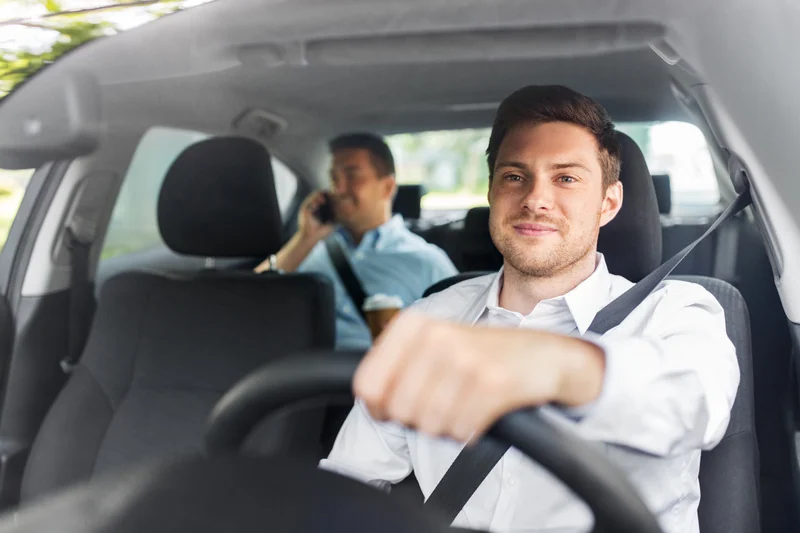 A Miwayz driver at the wheel with a passenger in the back seat